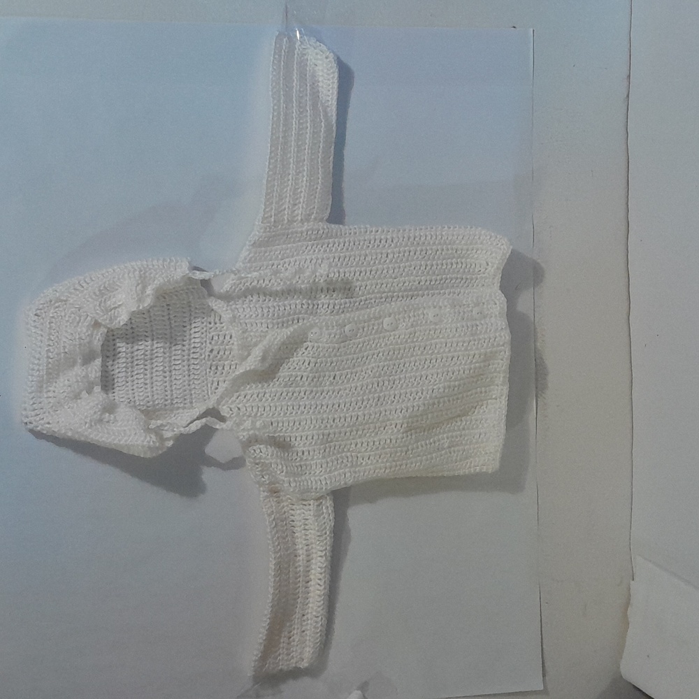 A white cream color crocheted hoodie.